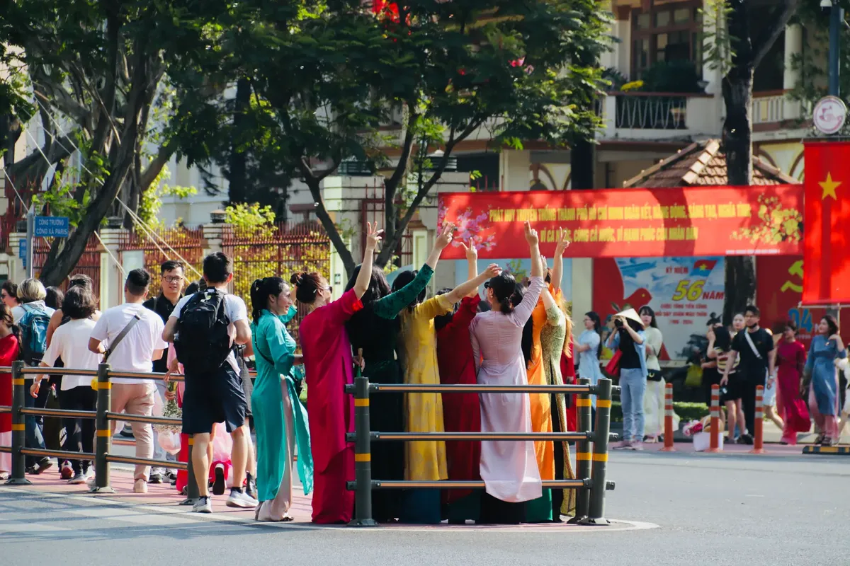 A lively street scene in Vietnam featuring a group dressed in traditional attire celebrating outdoors.