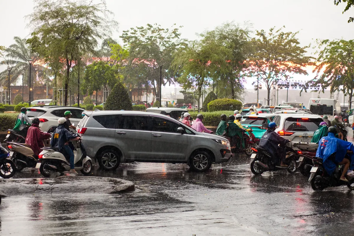 繁忙的街道，有機動車和汽車在大雨中，城市風景。