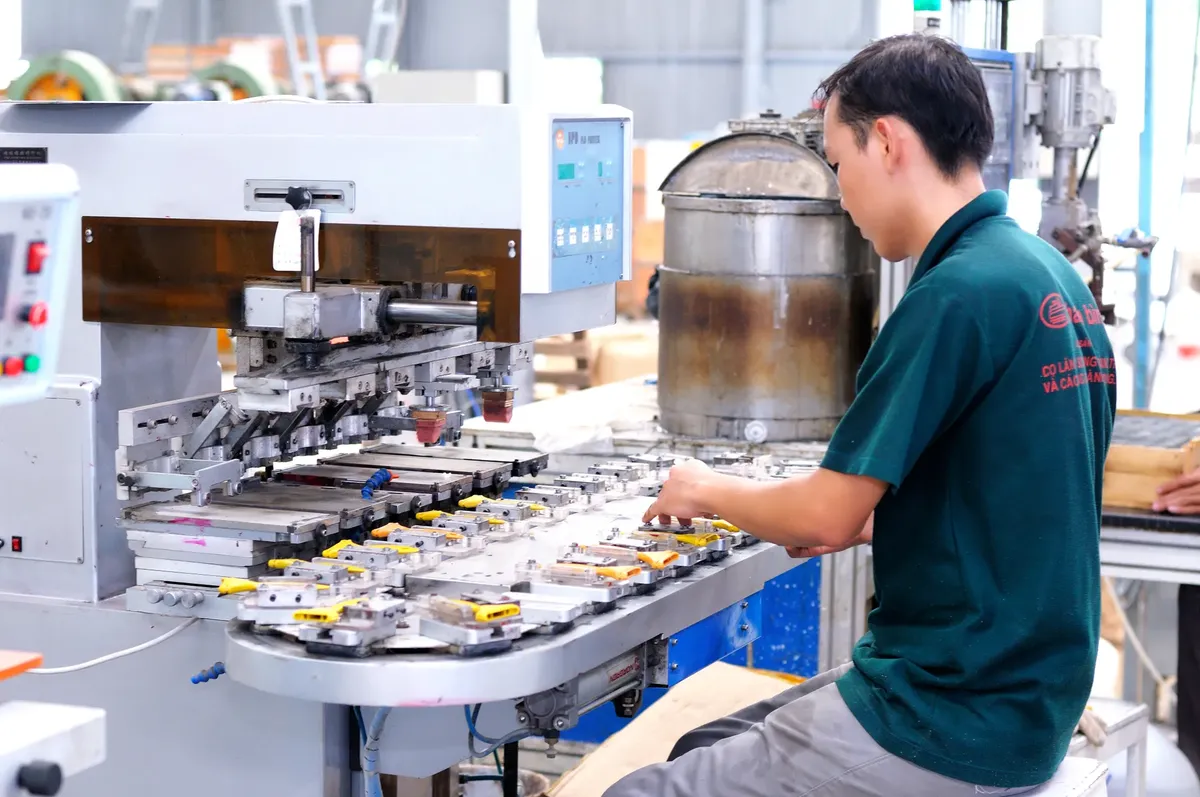 現代的な工場で機械を操作しているアジア系男性労働者。
